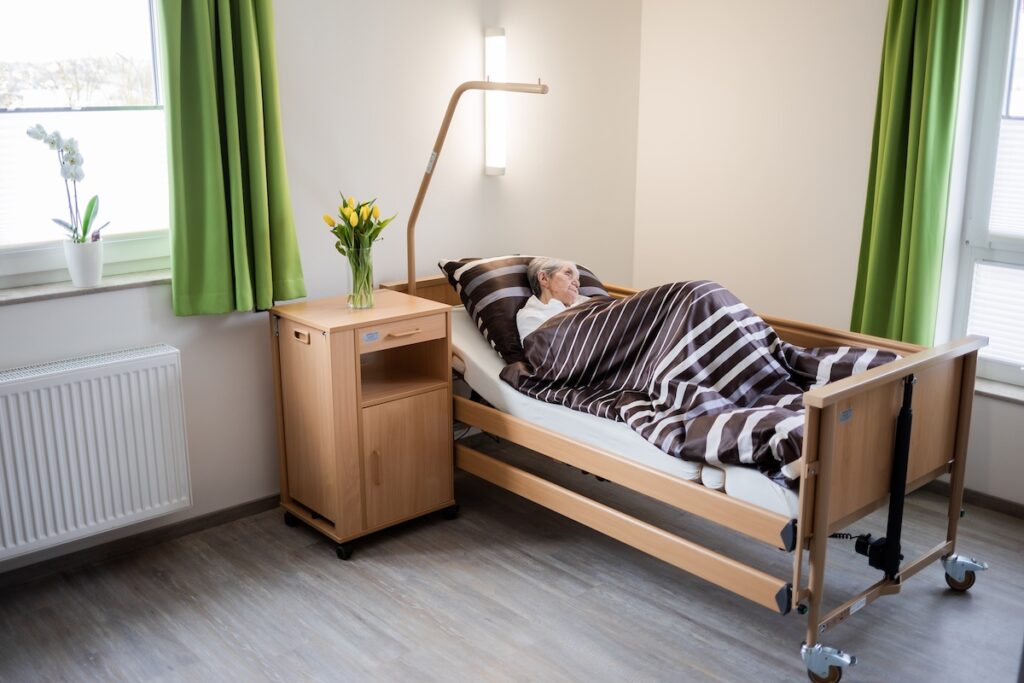 Bett für pflegebedürftige Person in hellem, modernem Raum